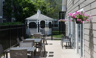 an outdoor dining area with several tables and chairs , as well as a gazebo in the background at Residence Inn Boston Westford
