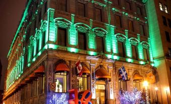 a building with green and white lights illuminating the building , creating a festive atmosphere during the holiday season at LHotel