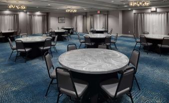 a large conference room with several round tables and chairs arranged in a circle , possibly for a meeting at Homewood Suites by Hilton Newburgh-Stewart Airport