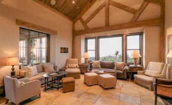 a spacious living room with high ceilings , wooden beams , and large windows that offer views of the outdoors at Rosewood Cape Kidnappers