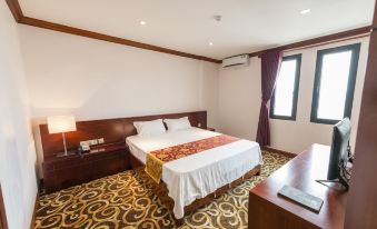 a hotel room with a king - sized bed , a tv , and a bathroom with a shower at Hoang Trung Co to Hotel