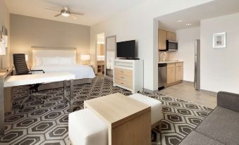 a modern living room with a couch , coffee table , and television in a hotel room at Homewood Suites by Hilton Salt Lake City Draper