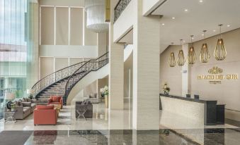 a modern hotel lobby with a staircase leading to the second floor , a reception desk , and various seating areas at Marcian Garden Hotel