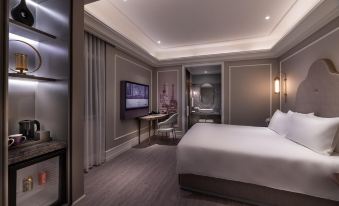The middle room features a spacious bed, along with a sitting area and desk attached to one side at Mercure Shanghai Yu Garden On the Bund