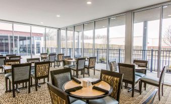 a dining area with several tables and chairs , a glass wall , and a view of the outdoors at Wyndham Avon