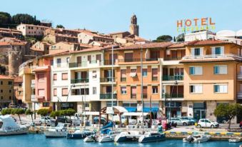 a picturesque coastal town with colorful buildings and boats , with the hotel sign in white letters at Hotel L'Approdo