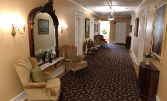 a long hallway with chairs and a large mirror , creating an inviting atmosphere for guests at Thayers Inn