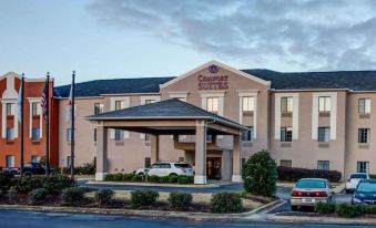 a holiday inn express hotel with a car parked in front and a red car in front of it at Comfort Suites Gadsden Attalla