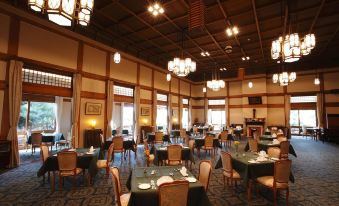 a large dining room with multiple tables and chairs arranged for a group of people to enjoy a meal together at Nara Hotel