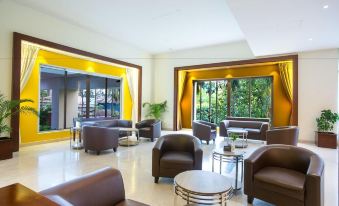 a modern living room with brown leather chairs and couches arranged in a seating area at Hotel Grand Park Barishal