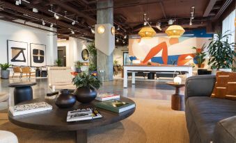 a modern living room with a large coffee table , potted plants , and a colorful painting on the wall at Wave Resort