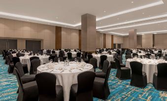 a large , well - lit banquet hall filled with tables and chairs , ready for a formal event at Park Inn by Radisson North Edsa