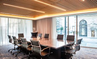 a large conference room with a wooden ceiling and chairs arranged in a semicircle around a table at The Charter Hotel Seattle, Curio Collection by Hilton