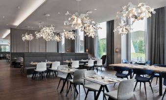 a modern dining room with several tables and chairs , creating a cozy atmosphere for guests at Courtyard Munich Garching