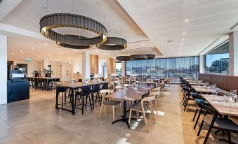 a large , modern restaurant with multiple dining tables and chairs , creating an inviting atmosphere for guests at Ingot Hotel Perth, Ascend Hotel Collection