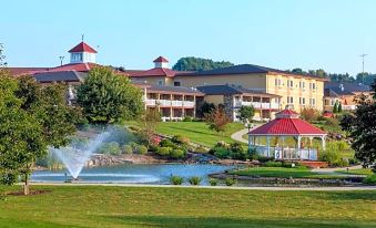 a large building with a red roof is surrounded by water and greenery , including a fountain at Berlin Resort