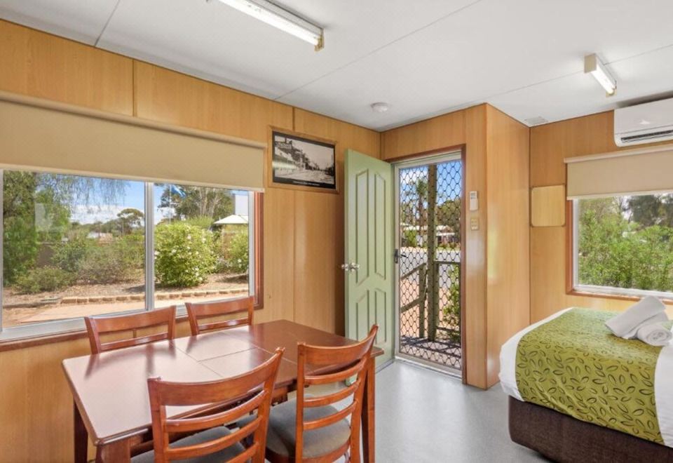 a bedroom with a bed , chairs , and a table is shown with a view of the outdoors at Discovery Parks - Port Augusta