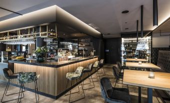 a modern restaurant with a bar and dining area , featuring a variety of chairs and tables at Hotel Post Alpine Cityflair