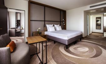 a modern bedroom with a large bed , a desk , and a mirror on the wall at Stuttgart Marriott Hotel Sindelfingen