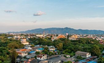 a panoramic view of a city with mountains in the background and buildings in the foreground at Rattanachol Hotel
