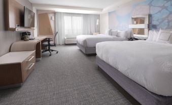 a modern hotel room with two beds , a desk , and a window , all neatly arranged at Courtyard Austin Pflugerville and Pflugerville Conference Center