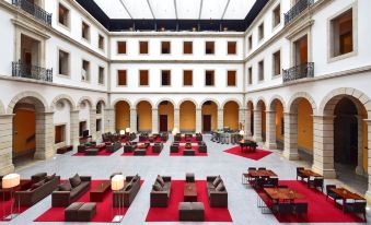 an indoor courtyard with a large open space filled with couches and tables , creating a comfortable and inviting atmosphere at Pousada De Viseu