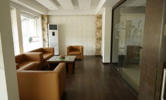 a spacious , well - lit living room with brown leather furniture and a window offering views of the city at The Palms Hotel