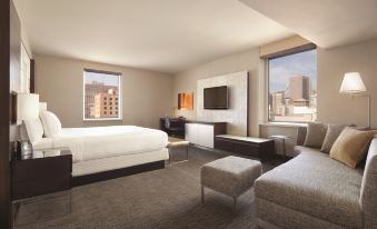 a modern hotel room with a large window offering views of the city , a bed , and a couch , all neatly arranged at Hilton San Francisco Union Square