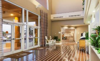 a spacious hotel lobby with wooden flooring , multiple doors , and a reception desk , giving an impression of comfort and convenience at DoubleTree Suites by Hilton Melbourne Beach Oceanfront
