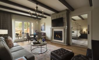 a spacious living room with a fireplace , large windows , and a dining area adjacent to it at Bernardus Lodge & Spa