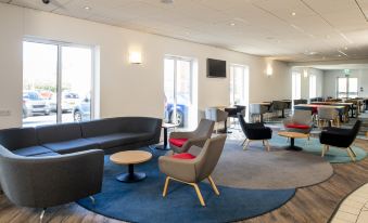 a modern waiting room with several chairs and couches , creating a comfortable and inviting atmosphere at Holiday Inn Express Newcastle Gateshead