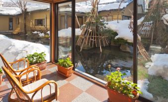 a room with a view of a pond and a teepee , surrounded by potted plants at Shosenkaku Kagetsu