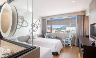 a modern hotel room with two beds , a desk , and a window overlooking the city at Pearl Hotel