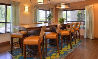 a bar area with several chairs and tables , creating a cozy atmosphere in the room at Hampton Inn Portland East