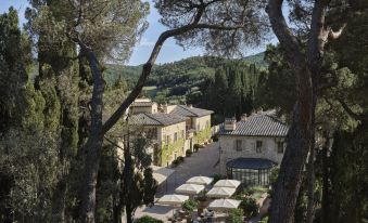 a large stone building surrounded by trees , with a courtyard in the middle of the scene at Rosewood Castiglion del Bosco