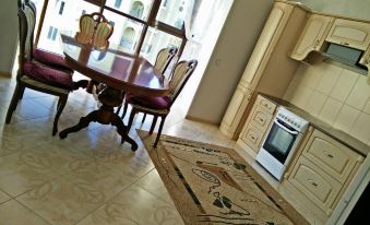 a kitchen with a dining table , chairs , and a rug in front of a window at Luxury Apartment