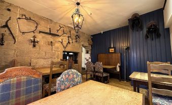 a dining room with wooden furniture , including a dining table and chairs , as well as a fireplace in the background at The Bear Inn
