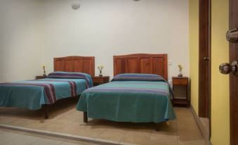 a room with two beds , one on the left side and the other on the right side at Hotel Restaurante Donaji