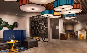 a modern lobby with a geometric wall and colorful pendant lights , featuring black seating and a blue couch at GLo Best Western Kanata Ottawa West