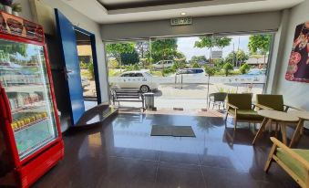 a modern office building with large glass doors , wooden floors , and a car parked outside at De' Chukai Hotel