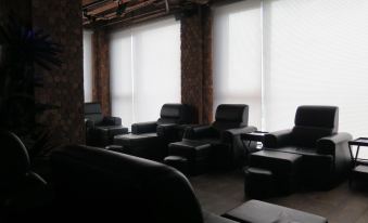 a room with several black leather chairs arranged in a row , along with a television at ABC Hotel