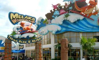 a large sign for melaka wonderland amusement park in the center of a bustling city , with various rides and attractions on display at Sun Inns Hotel Ayer Keroh