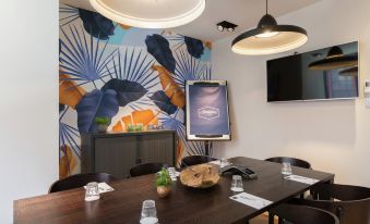 a conference room with a large table , chairs , and a tv mounted on the wall at Hampton by Hilton Antwerp Central Station