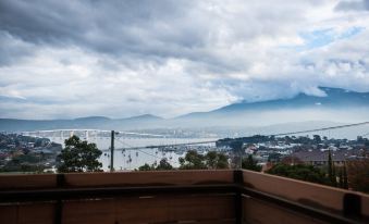 a view of a city with mountains in the background and clouds in the sky at Beltana Hotel
