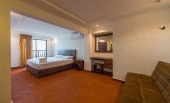 a spacious bedroom with a large bed , a desk , and a chair in the room at Hotel Rio Lagartos