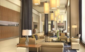 a modern hotel lobby with a large chandelier hanging from the ceiling , creating an elegant atmosphere at DoubleTree by Hilton Cedar Rapids Convention Complex