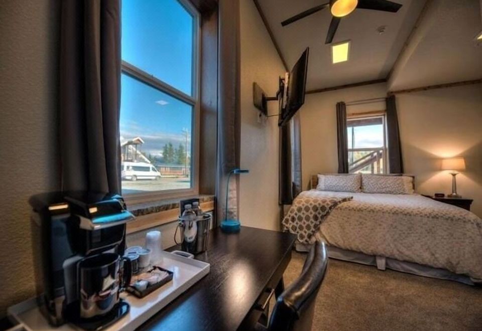 a hotel room with a bed , desk , and microwave , offering a view of the mountains outside the window at The Cannery Lodge