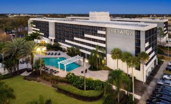 an aerial view of a large hotel with a swimming pool , surrounded by palm trees and grass at Sheraton Orlando North Hotel