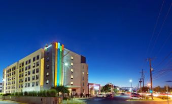 a large hotel building with colorful lights is situated on a city street at night at Even Hotel Rockville - Washington, DC Area, an IHG Hotel