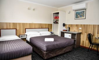a hotel room with two beds , one on the left and one on the right side of the room at Hobart Tower Motel